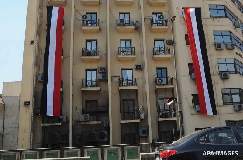 Egyptian walk past Egyptian flags during the first day of a three days trip for the inauguration of the new Suez channel, in cairo, Egypt, Thursday, Aug. 6, 2015. Egypt is to unveil a major extension of the Suez Canal th...