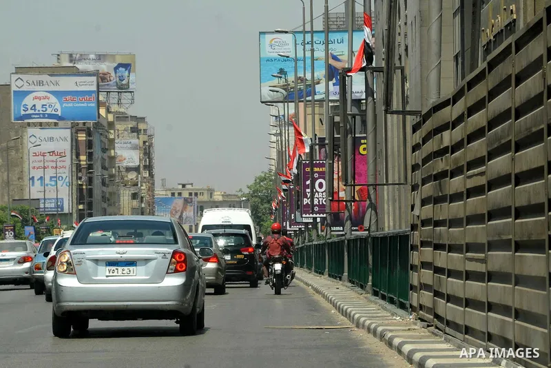Egyptian walk past a billboard during the first day of a three days trip for the inauguration of the new Suez channel, in cairo, Egypt, Thursday, Aug. 6, 2015. Egypt is to unveil a major extension of the Suez Canal that...