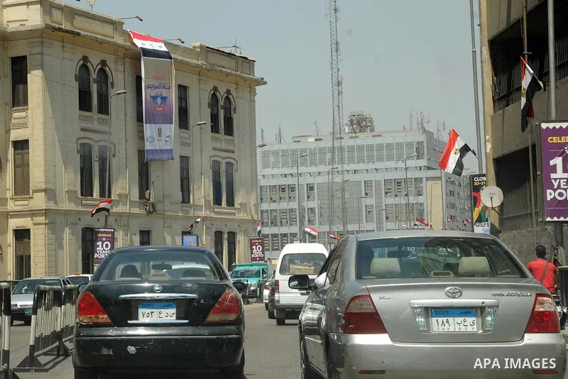 Egyptian walk past a billboard during the first day of a three days trip for the inauguration of the new Suez channel, in cairo, Egypt, Thursday, Aug. 6, 2015. Egypt is to unveil a major extension of the Suez Canal that...