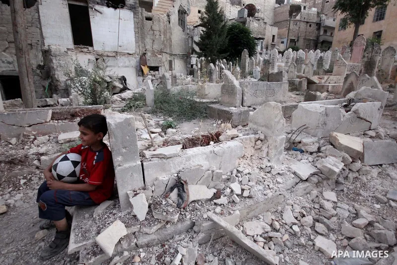 A Syrian boy watches as medics bury a body of 10-month-old baby girl that killed following a shelling attack by forces of Syria's President Bashar al-Assad, in the northern Syrian city of Aleppo, on August 6, 2015. Photo...