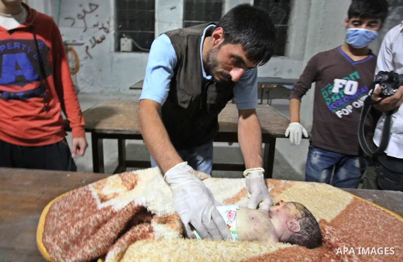 Syrian medics inspect a body of 10-month-old baby girl that killed following a shelling attack by forces of Syria's President Bashar al-Assad, in the northern Syrian city of Aleppo, on August 6, 2015. Photo by Ameer al-H...