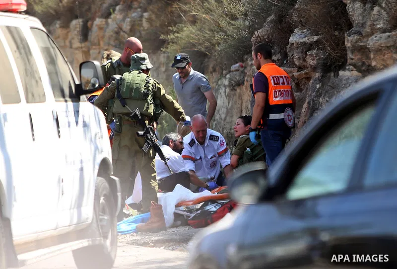 Israeli medics treat a wounded man following rammed in a suspected attack by a Palestinian motorist, near the West Bank city of Ramallah on August 6, 2015. Israeli forces shot and injured a Palestinian man on Thursday af...