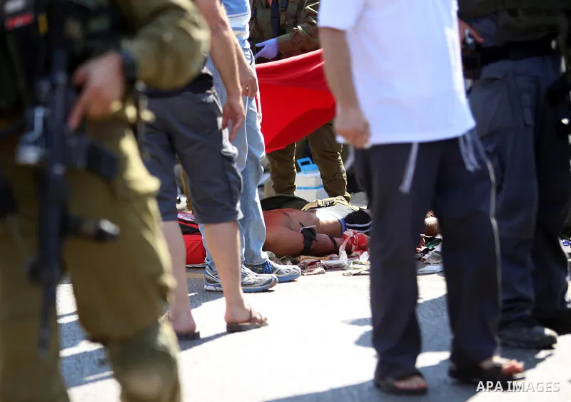 Israeli medics treat a wounded man following rammed in a suspected attack by a Palestinian motorist, near the West Bank city of Ramallah on August 6, 2015. Israeli forces shot and injured a Palestinian man on Thursday af...