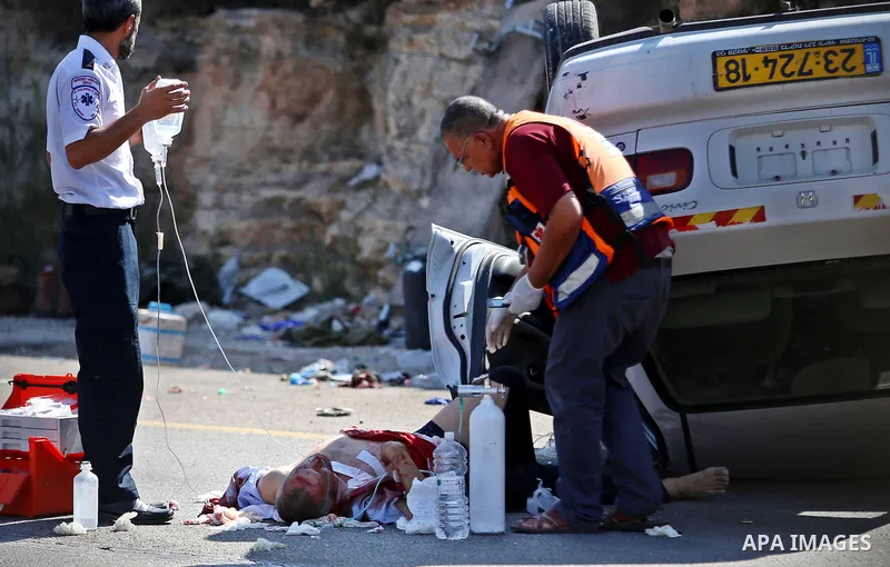 Israeli medics treat a wounded man following rammed in a suspected attack by a Palestinian motorist, near the West Bank city of Ramallah on August 6, 2015. Israeli forces shot and injured a Palestinian man on Thursday af...