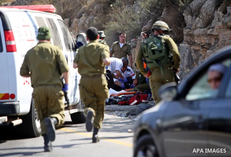 Israeli medics treat a wounded man following rammed in a suspected attack by a Palestinian motorist, near the West Bank city of Ramallah on August 6, 2015. Israeli forces shot and injured a Palestinian man on Thursday af...