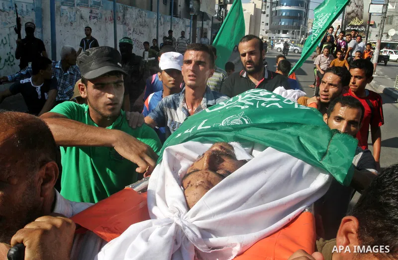 Mourners carry a body of one of three victims from Abu Nuqeira family, who were killed in an explosion that ripped through a house in the Al-Shabura refugee camp near the southern Gaza Strip town of Rafah, during their f...