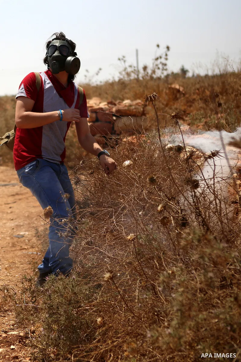 A Palestinian protester hurls stones at Israeli troops during clashes following a protest against Jewish settlements and the expropriation of Palestinian land in the West Bank village of Nabi Saleh, near Ramallah August...