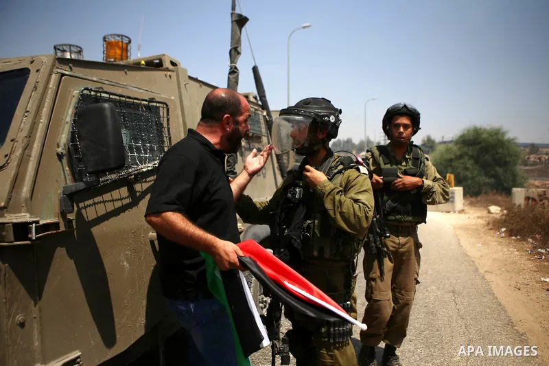 A Palestinian protester argues with Israeli security forces during clashes following a protest against Jewish settlements and the expropriation of Palestinian land in the West Bank village of Nabi Saleh, near Ramallah Au...