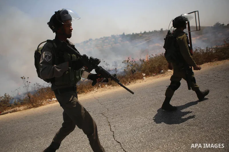 Israeli security forces take position during clashes with Palestinian protesters following a protest against Jewish settlements and the expropriation of Palestinian land in the West Bank village of Nabi Saleh, near Ramal...