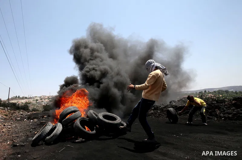 Palestinian protesters burn tires during clashes with Israeli security forces following a protest against the expropriation of Palestinian land by Israel in the West Bank village of Kafr Qaddum, near the northern city of...