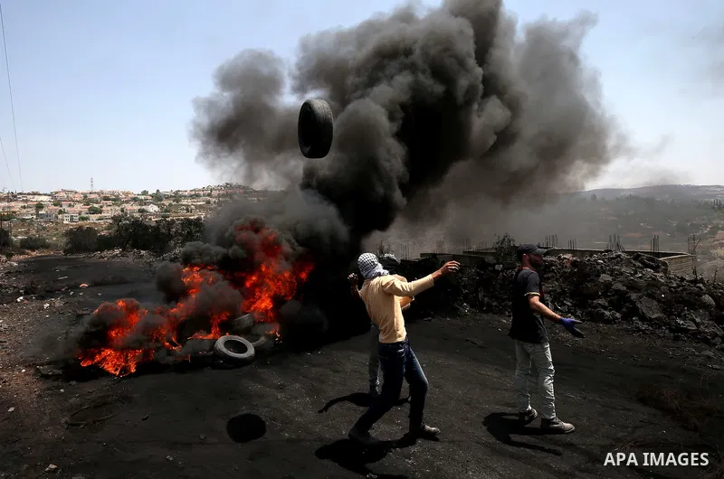 Palestinian protesters burn tires during clashes with Israeli security forces following a protest against the expropriation of Palestinian land by Israel in the West Bank village of Kafr Qaddum, near the northern city of...