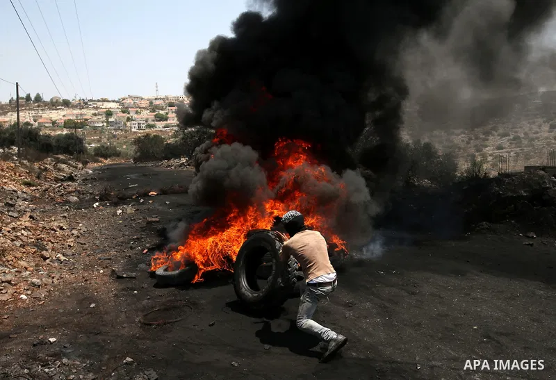 Palestinian protesters burn tires during clashes with Israeli security forces following a protest against the expropriation of Palestinian land by Israel in the West Bank village of Kafr Qaddum, near the northern city of...