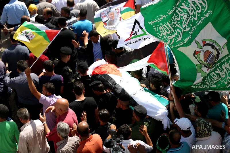 Palestinian mourners carry the body of Saad Dawabsha, the father of a Palestinian toddler killed last week when their home was firebombed by Jewish extremists, during his funeral in the West Bank village of Duma on Augus...