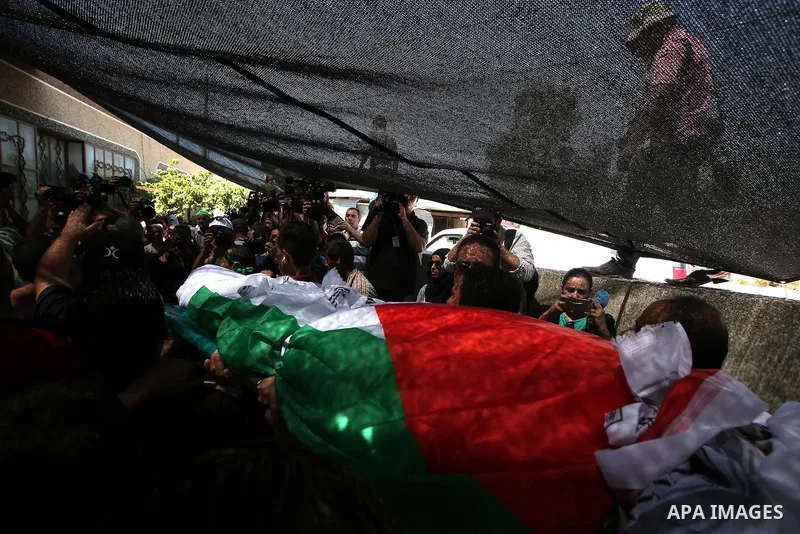 Palestinian mourners carry the body of Saad Dawabsha, the father of a Palestinian toddler killed last week when their home was firebombed by Jewish extremists, during his funeral in the West Bank village of Duma on Augus...