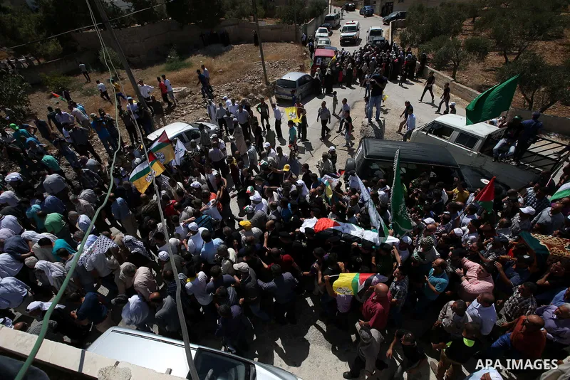 Palestinian mourners carry the body of Saad Dawabsha, the father of a Palestinian toddler killed last week when their home was firebombed by Jewish extremists, during his funeral in the West Bank village of Duma on Augus...