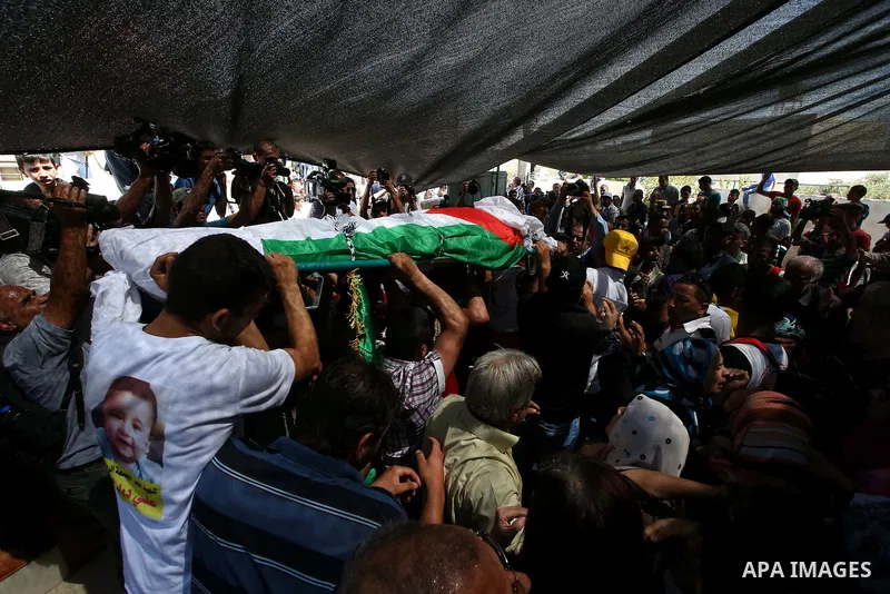 Palestinian mourners carry the body of Saad Dawabsha, the father of a Palestinian toddler killed last week when their home was firebombed by Jewish extremists, during his funeral in the West Bank village of Duma on Augus...