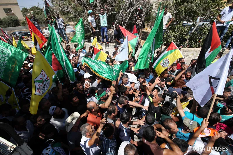Palestinian mourners carry the body of Saad Dawabsha, the father of a Palestinian toddler killed last week when their home was firebombed by Jewish extremists, during his funeral in the West Bank village of Duma on Augus...