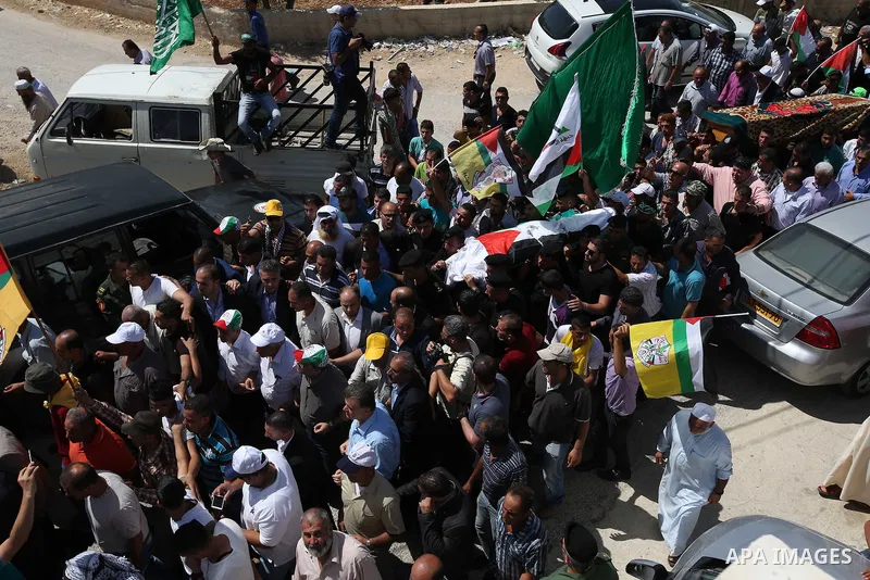 Palestinian mourners carry the body of Saad Dawabsha, the father of a Palestinian toddler killed last week when their home was firebombed by Jewish extremists, during his funeral in the West Bank village of Duma on Augus...