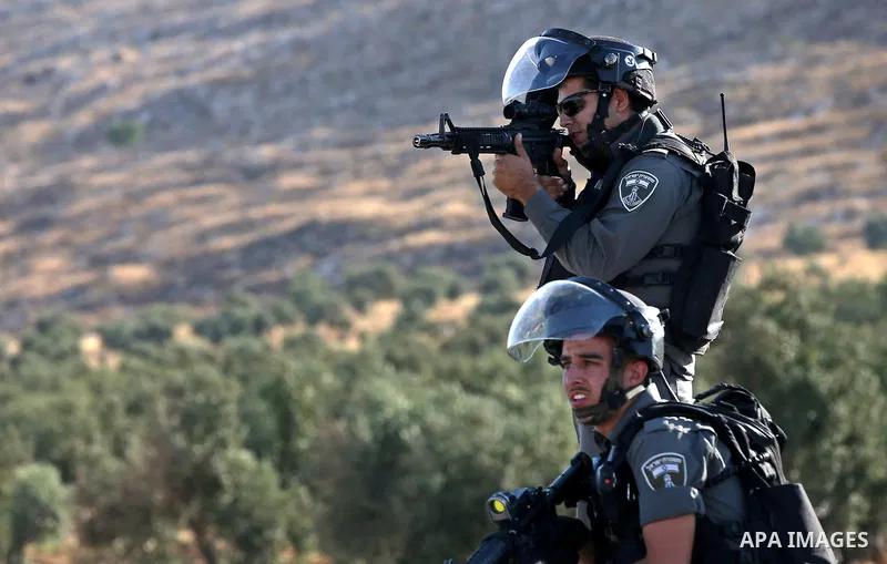 Israeli security forces take position during clashes with Palestinian protesters on a street leading to Duma village, in a demonstration following the funeral of Saad Dawabsha, the father of a Palestinian toddler killed...