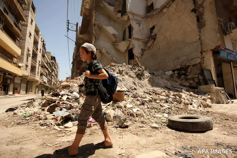 Fouad, a 11-year-old Syrian boy, walks on his way to school in a rebel-controlled area of Aleppo, on August 8, 2015. Fouad works everyday following the school time to provide for his small family, as his father suffers f...