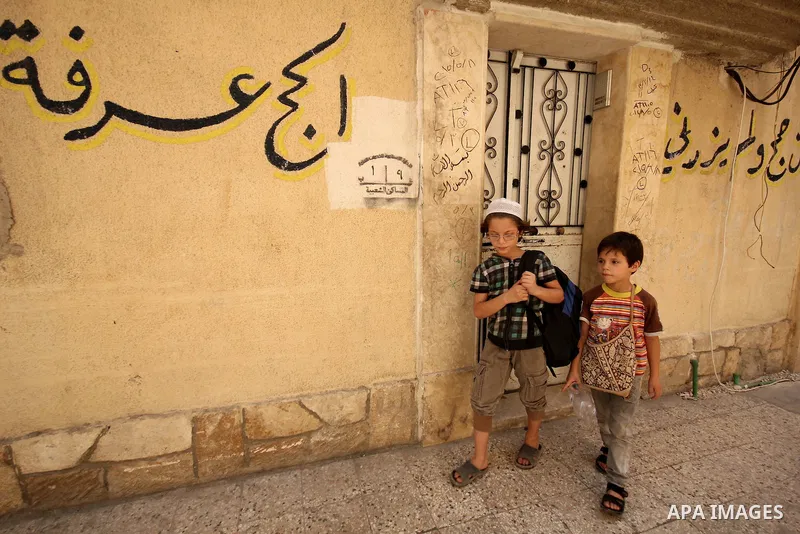 Fouad, a 11-year-old Syrian boy, walks on his way to school in a rebel-controlled area of Aleppo, on August 8, 2015. Fouad works everyday following the school time to provide for his small family, as his father suffers f...