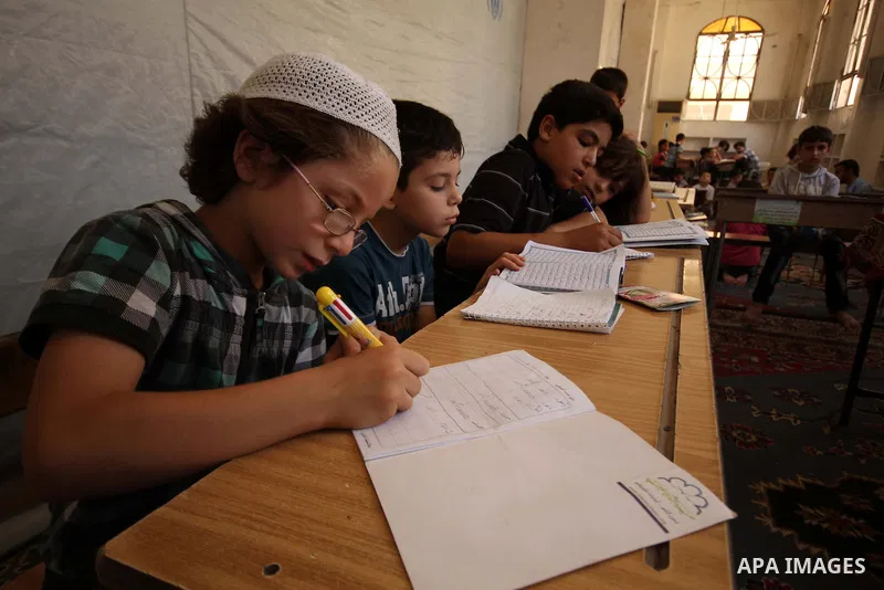 Fouad, a 11-year-old Syrian boy, sits in a classroom in a school in a rebel-controlled area of Aleppo, on August 8, 2015. Fouad works everyday following the school time to provide for his small family, as his father suff...