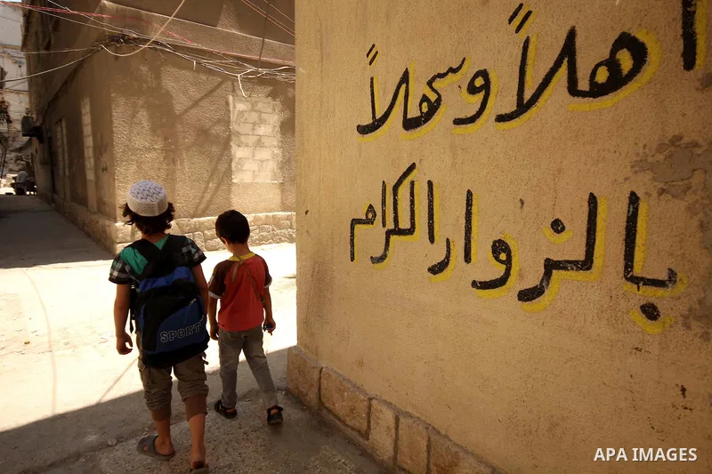 Fouad, a 11-year-old Syrian boy, walks on his way to school in a rebel-controlled area of Aleppo, on August 8, 2015. Fouad works everyday following the school time to provide for his small family, as his father suffers f...