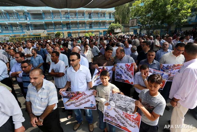 Palestinian Teachers hold banners during a protest against the reduction of educational programs given by United Nations Relief and Works Agency (UNRWA) in Jabalia in the northern of Gaza strip on August 9, 2015. The UNR...