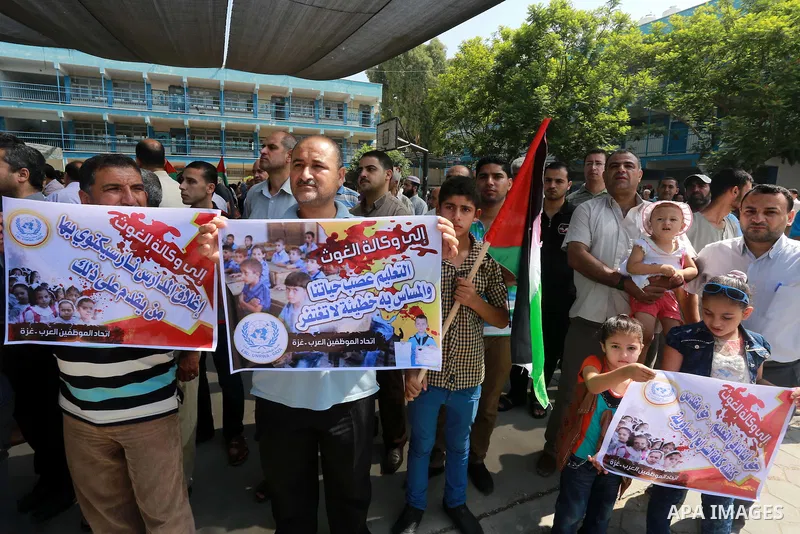 Palestinian Teachers hold banners during a protest against the reduction of educational programs given by United Nations Relief and Works Agency (UNRWA) in Jabalia in the northern of Gaza strip on August 9, 2015. The UNR...