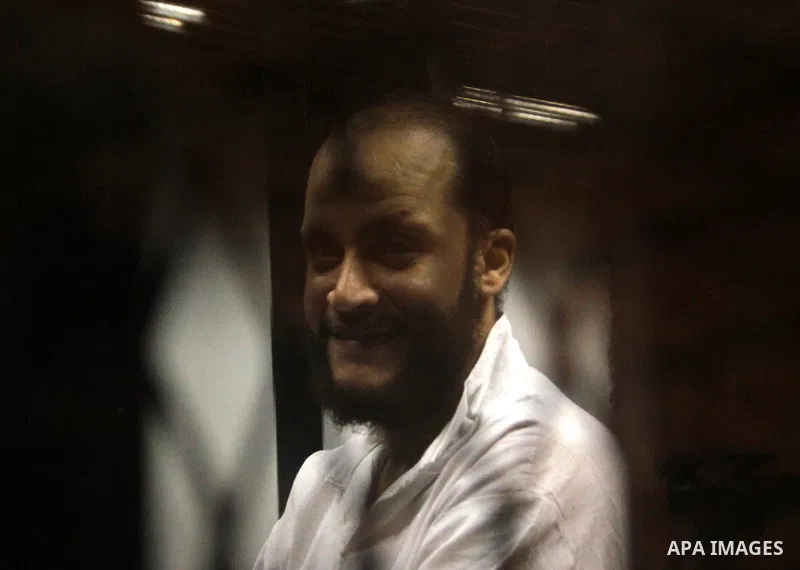 An Egyptian Muslim Brotherhood defendant sits behind the bars during his trial, along with ousted Islamist president Mohamed Morsi (unseen), in a court in Cairo on August 9, 2015. Cairo Criminal Court resumes on Saturday...