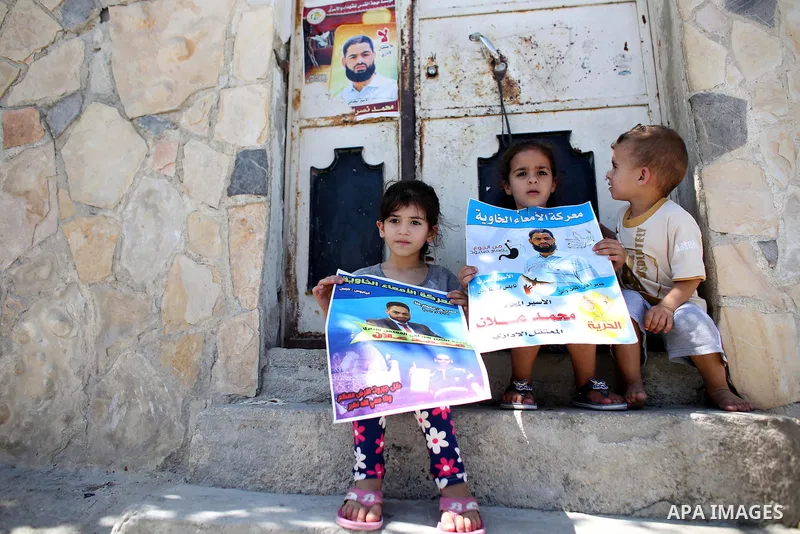 Relatives of Palestinian prisoner in Israeli jails Mohammad Allan, hold his portraits at the entrance of his house in the village of Ainabos, south of Nablus in the occupied West Bank, on August 9, 2015. The Israeli mili...