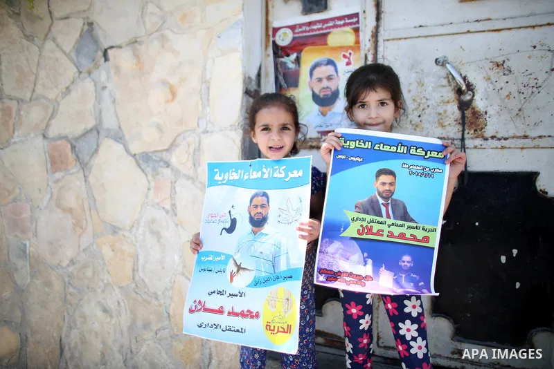 Relatives of Palestinian prisoner in Israeli jails Mohammad Allan, hold his portraits at the entrance of his house in the village of Ainabos, south of Nablus in the occupied West Bank, on August 9, 2015. The Israeli mili...