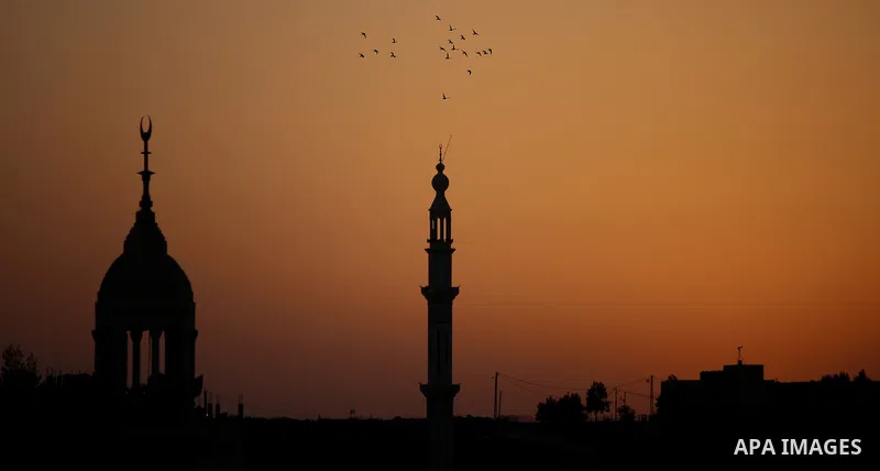 Seagulls fly around the minaret of Hera' mosque, during the sunset in Jalazoun refugee camp, near the West Bank city of Ramallah, on August 9, 2015. Photo by Shadi Hatem