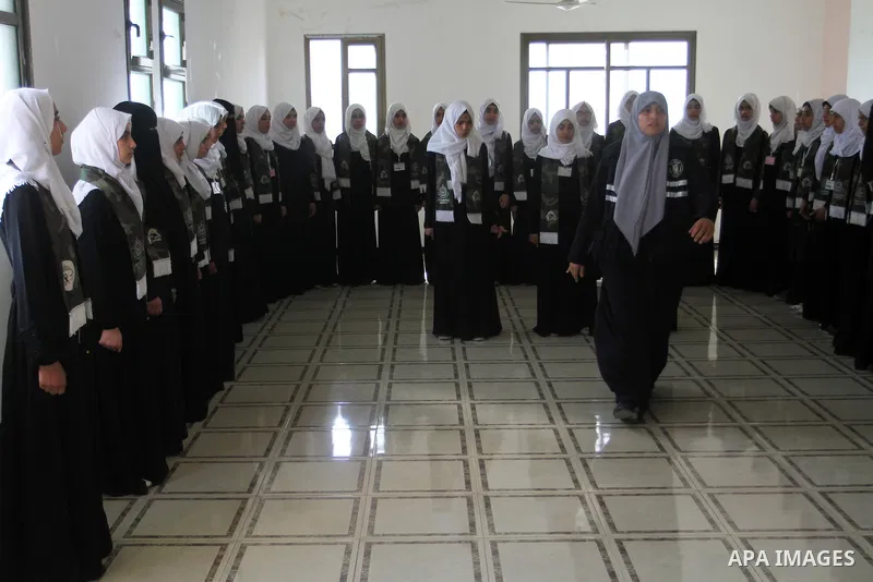 Palestinian girls take part in a graduation ceremony of a military-style camp organized by the Hamas movement, in Rafah in the southern Gaza strip, on August 10, 2015. Photo by Abed Rahim Khatib