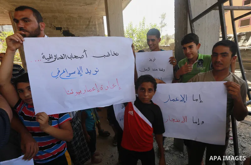 Palestinians take part in a protest demanding reconstruction of houses which were destroyed during the recent Israeli war, in Gaza city, on August 10, 2015. Photo by Mohammed Asad