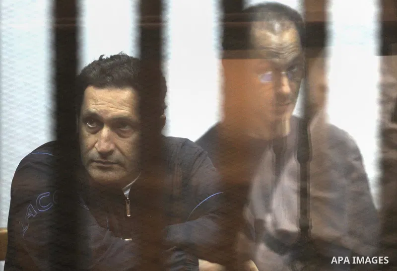 Alaa and Gamal Mubarak, the sons of former former president Hosni Mubarak sit in a courtroom cage during their trial in Cairo on August 11, 2015. Cairo Criminal Court held at Police Academy adjourned Gamal and Alaa Mubar...