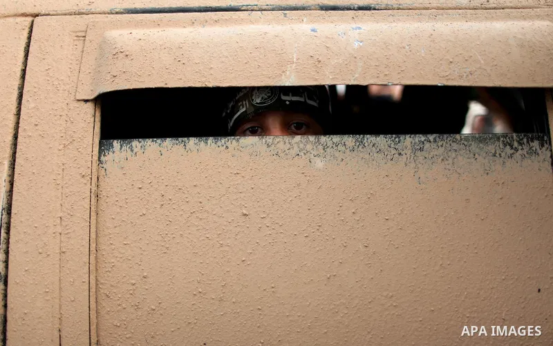 A Palestinian boy looks on from a military vehicle as members of Ezzedeen al-Qassam brigades, the armed wing of Hamas movement, take part in an anti-Israel parade in Beit Hanoun, in the northern Gaza Strip, on August 11,...