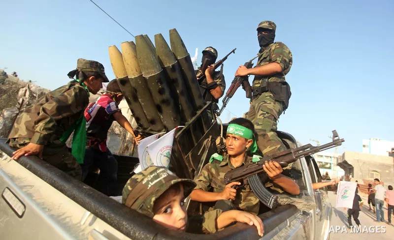 A Palestinian boy looks on from a military vehicle as members of Ezzedeen al-Qassam brigades, the armed wing of Hamas movement, take part in an anti-Israel parade in Beit Hanoun, in the northern Gaza Strip, on August 11,...