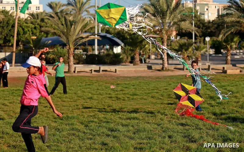 Palestinian children fly kites in a protest against the Israeli blockade on the Gaza Strip and demanding for opening the Rafah crossing, in Gaza city on August 12, 2015. Photo by Yasser Qudih