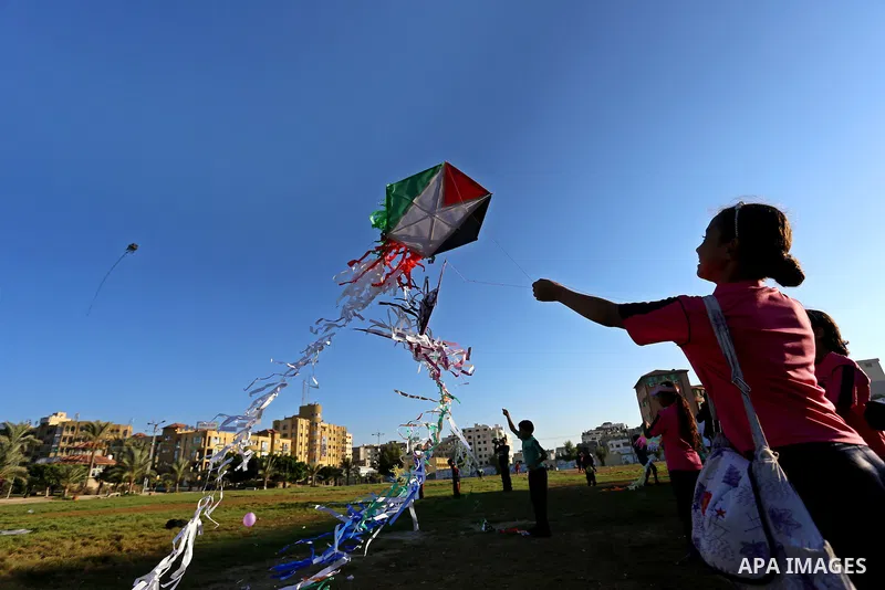 Palestinian children fly kites in a protest against the Israeli blockade on the Gaza Strip and demanding for opening the Rafah crossing, in Gaza city on August 12, 2015. Photo by Yasser Qudih
