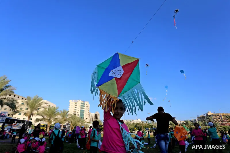 Palestinian children fly kites in a protest against the Israeli blockade on the Gaza Strip and demanding for opening the Rafah crossing, in Gaza city on August 12, 2015. Photo by Yasser Qudih