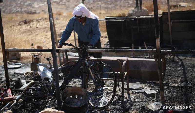 A Palestinian man inspects his a tent burned by Jewish extremists in the area of Ein Samiya near Kafr Malik village in northern Ramallah, on August, 13, 2015. A group of Israeli settlers raided the village of Ein Samiya...