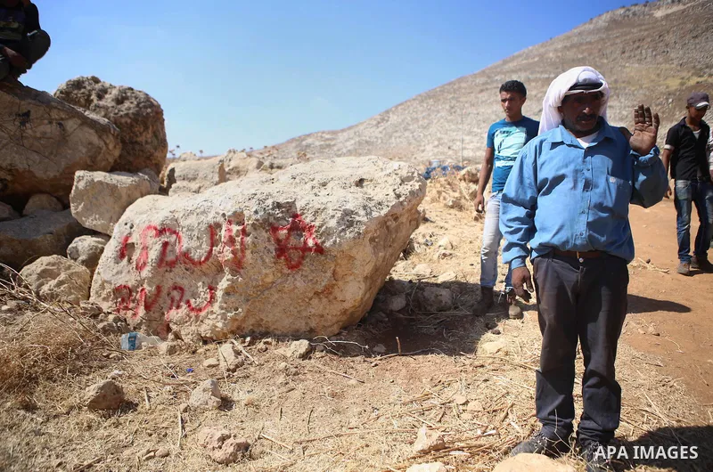 Palestinians inspect a tent burned by Jewish extremists in the area of Ein Samiya near Kafr Malik village in northern Ramallah, on August, 13, 2015. A group of Israeli settlers raided the village of Ein Samiya and threw...