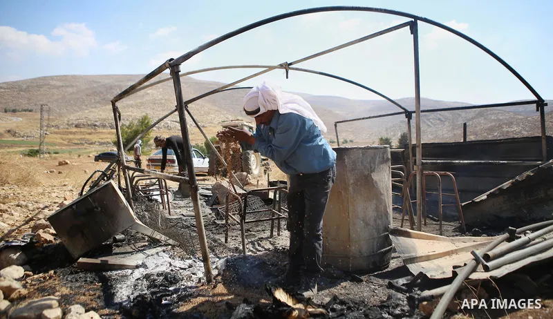A Palestinian man inspects his a tent burned by Jewish extremists in the area of Ein Samiya near Kafr Malik village in northern Ramallah, on August, 13, 2015. A group of Israeli settlers raided the village of Ein Samiya...