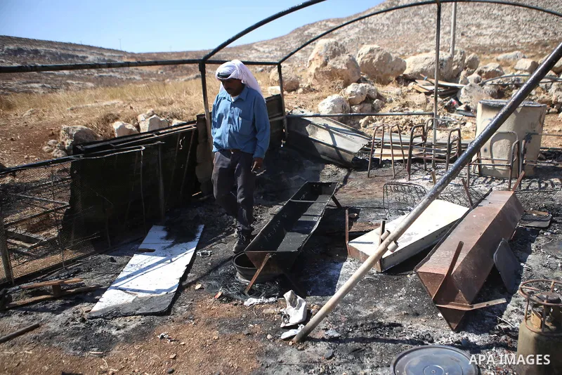 A Palestinian man inspects his a tent burned by Jewish extremists in the area of Ein Samiya near Kafr Malik village in northern Ramallah, on August, 13, 2015. A group of Israeli settlers raided the village of Ein Samiya...