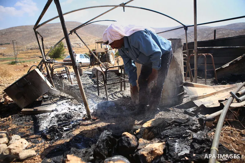 A Palestinian man inspects his a tent burned by Jewish extremists in the area of Ein Samiya near Kafr Malik village in northern Ramallah, on August, 13, 2015. A group of Israeli settlers raided the village of Ein Samiya...