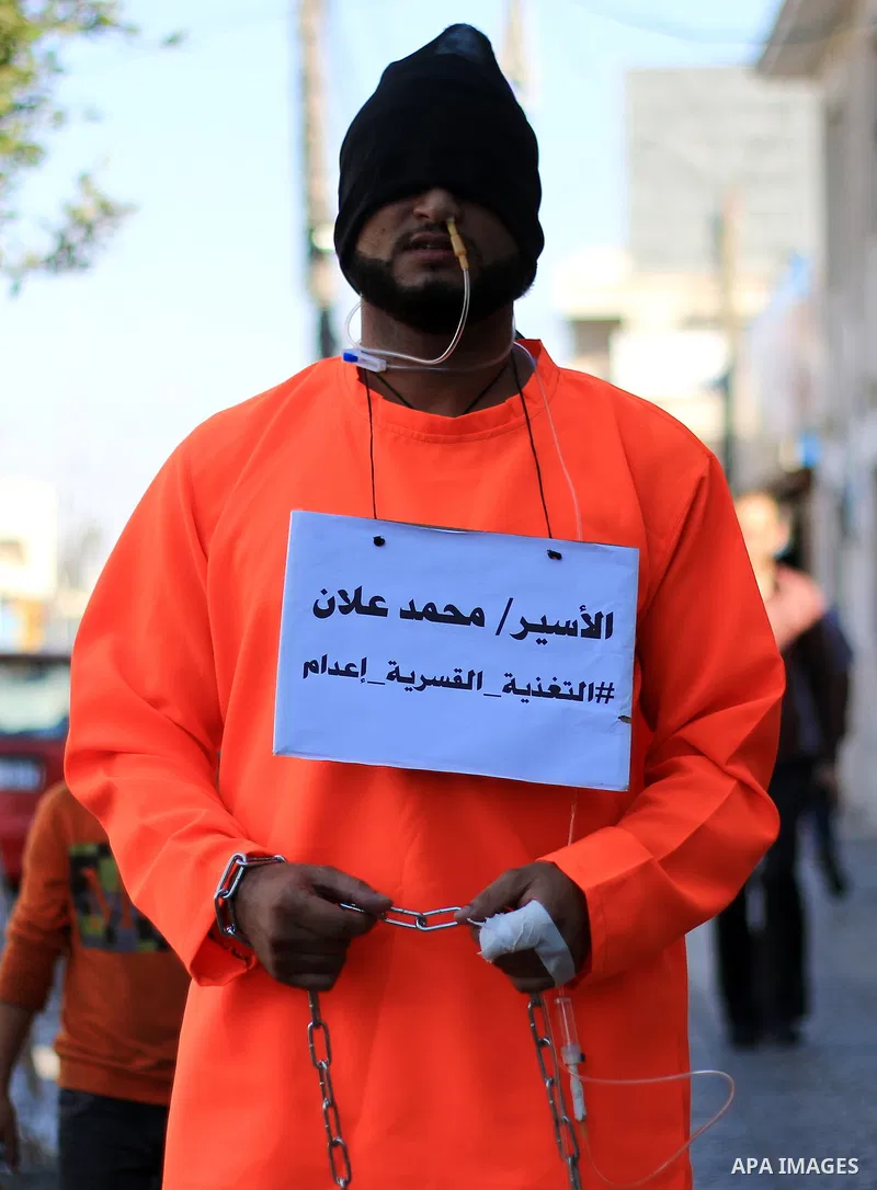 A man wearing prisoner's costume, walks in a street in solidarity with Mohammad Allan, a Palestinian prisoner in Israeli jail who has been on hunger strike for 60 consecutive days, in Gaza city on August 13, 2015. Allan,...