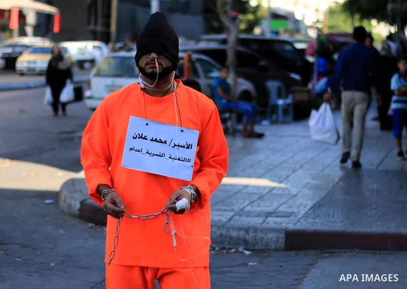 A man wearing prisoner's costume, walks in a street in solidarity with Mohammad Allan, a Palestinian prisoner in Israeli jail who has been on hunger strike for 60 consecutive days, in Gaza city on August 13, 2015. Allan,...