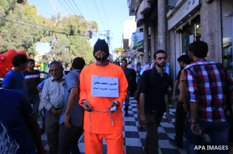 A man wearing prisoner's costume, walks in a street in solidarity with Mohammad Allan, a Palestinian prisoner in Israeli jail who has been on hunger strike for 60 consecutive days, in Gaza city on August 13, 2015. Allan,...