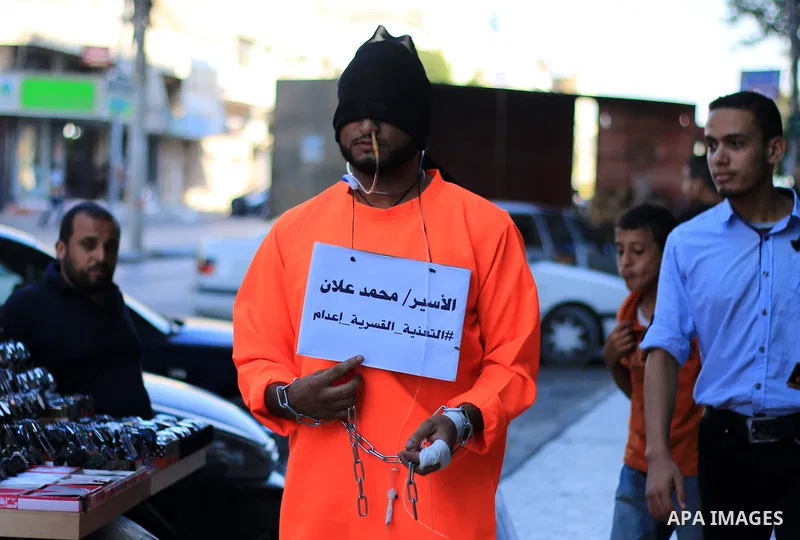 A man wearing prisoner's costume, walks in a street in solidarity with Mohammad Allan, a Palestinian prisoner in Israeli jail who has been on hunger strike for 60 consecutive days, in Gaza city on August 13, 2015. Allan,...